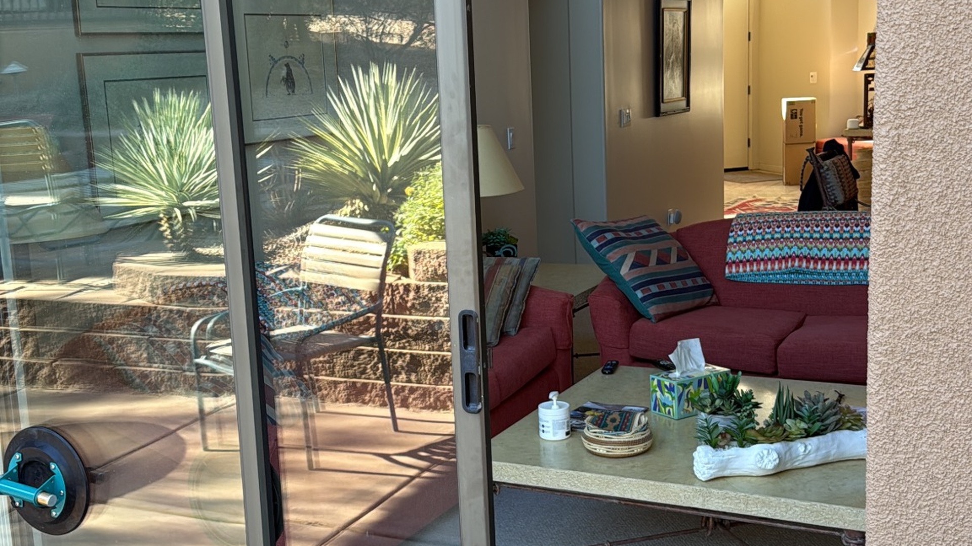 Sliding glass door partially open, revealing an outdoor patio and indoor living room.