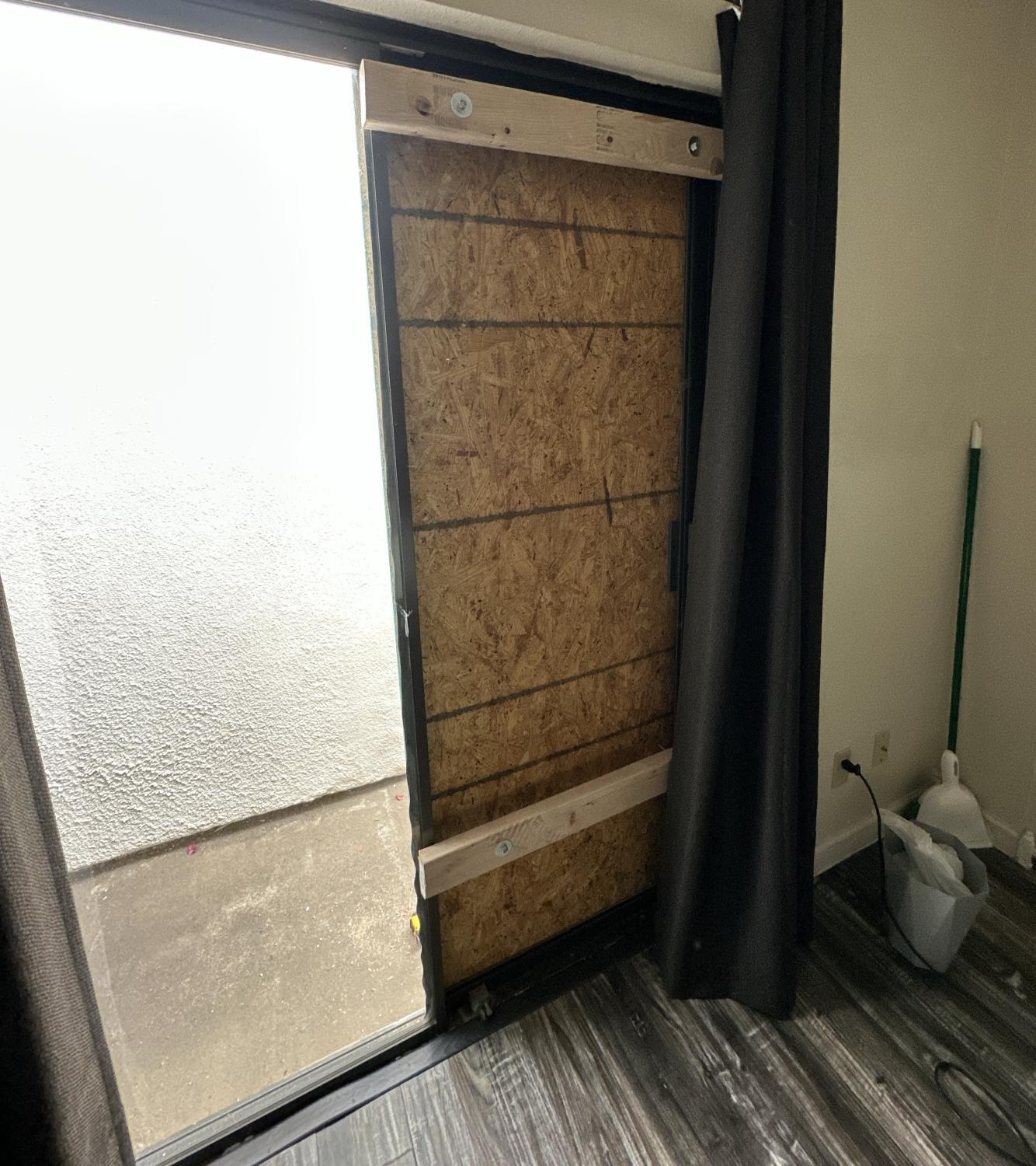 Temporary Plywood Board-Up on Sliding Glass Door Sliding glass door boarded up with plywood from the inside of a room